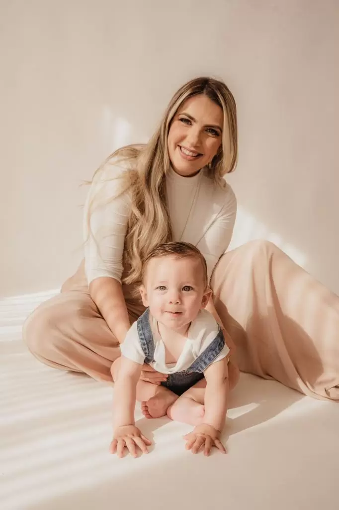 Bebê engatinhando e sorrindo durante ensaio fotográfico
