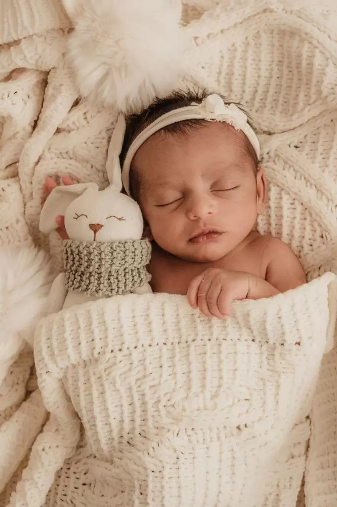 Recém-nascido de touquinha dormindo em ensaio newborn